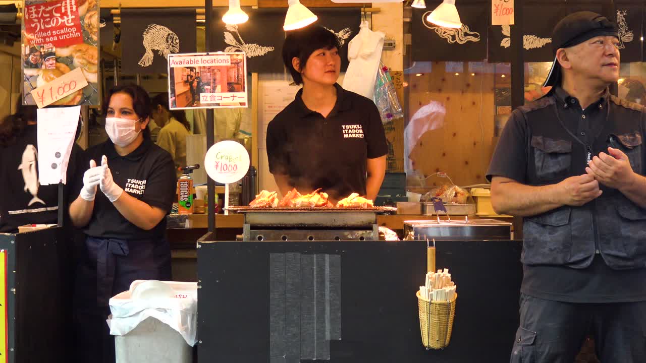 People selling food in front of shop in fish market