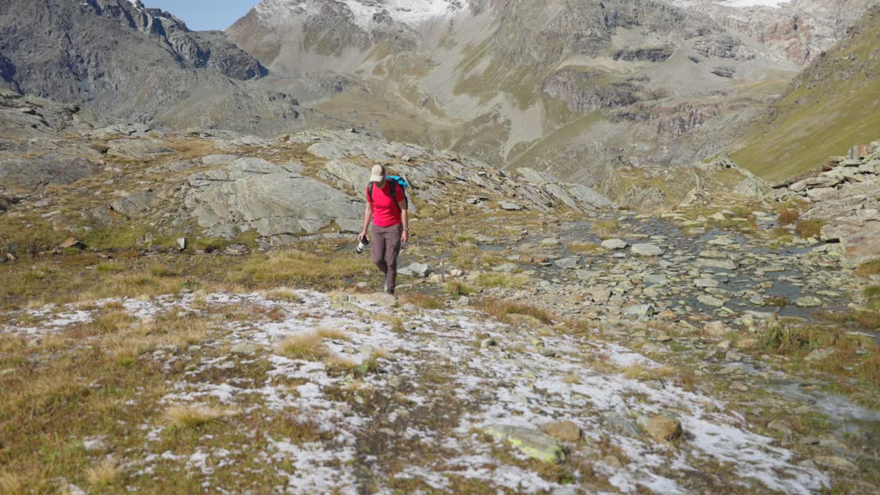 사진작가는 첫 눈이 내리는 가을의 산악 풍경을 걸어다닙니다.