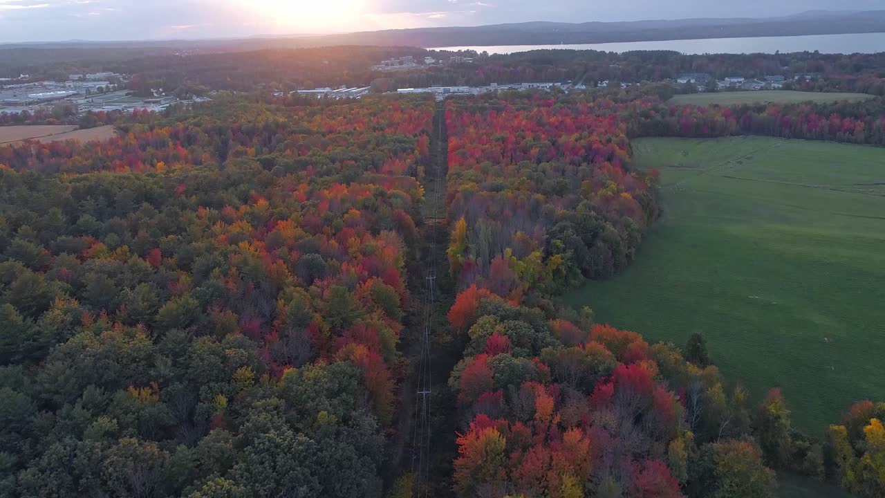 una ciudad desde lejos durante los meses de otoño, puesta de sol - video de drones