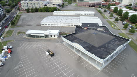 Aerial-Drone-over-empty-parking-lot,-construction-site,-building-to-be-demolished