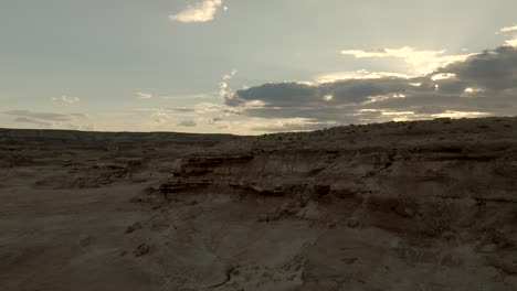 Ascending-over-a-desert-wasteland-and-rocky-cliffs-at-twilight