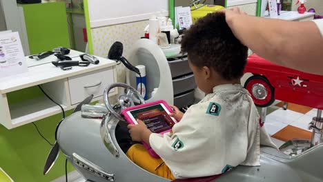 3-year-old black toddler in the hair saloon getting a haircut