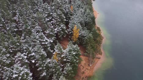 Bezaubernder-Roadtrip:-Ein-Stimmungsvolles-Abenteuer-Entlang-Einer-Seeuferstraße,-Umgeben-Von-Schnee-Und-Herbstlicher-Pracht-Im-Wald