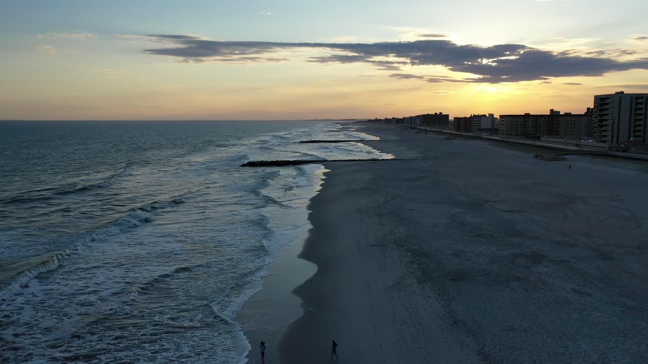 An aerial view of a quiet beach at sunset