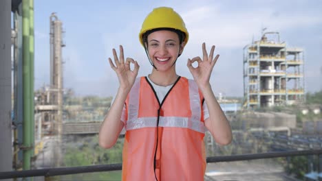 una trabajadora de la construcción india feliz que muestra una señal de bien