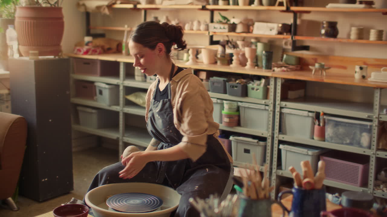 Female Artisan Preparing Clay for Wheel Throwing in Pottery Studio