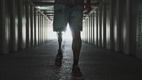 person with prosthetic leg walking through a tunnel
