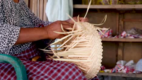 tejedor de canasta timorense tejiendo en timor-leste, sudeste de asia