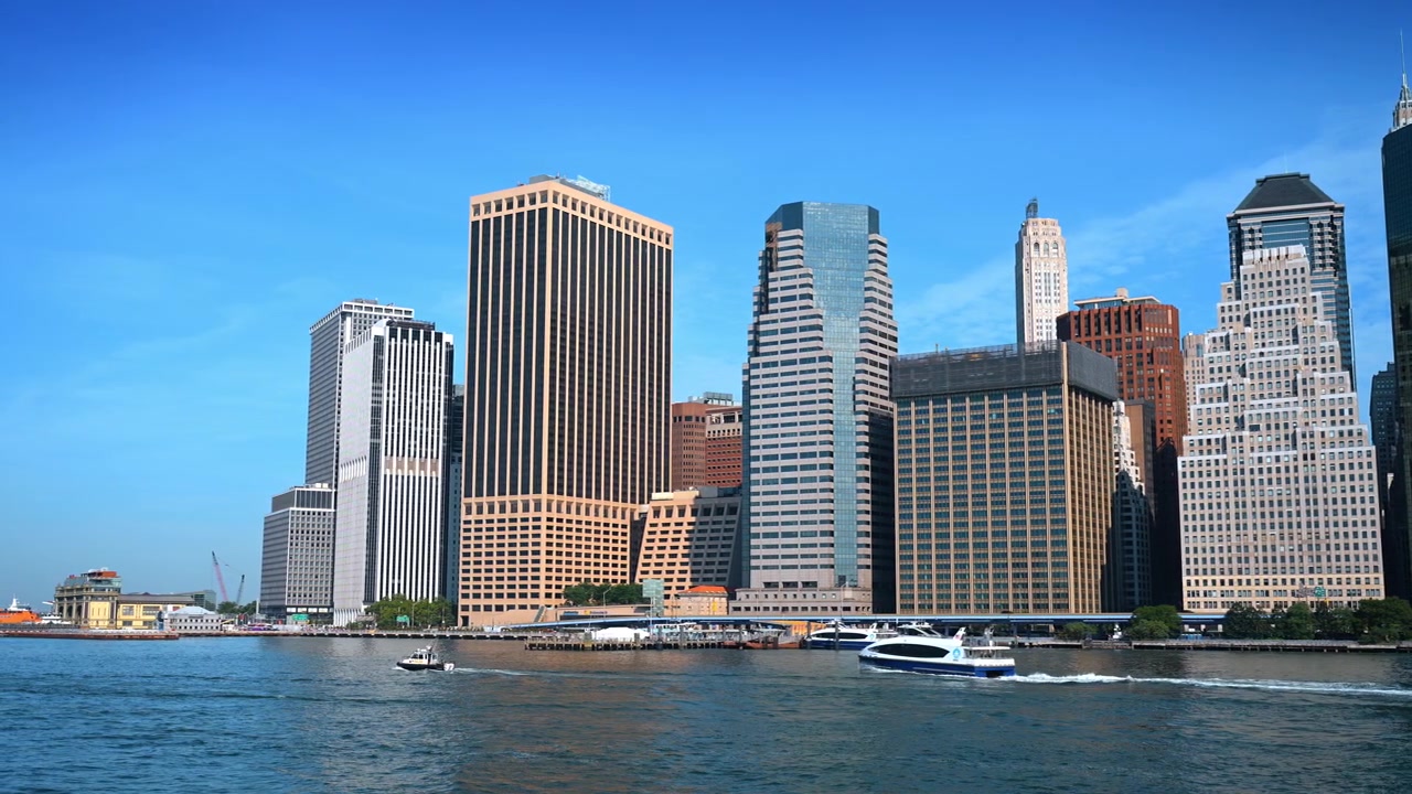 Vista do horizonte de Manhattan a partir do Rio Hudson em Nova York. Arranha-céus modernos sob um céu azul claro com balsas se movendo na água durante o dia