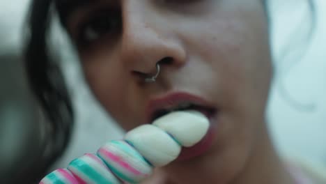 primer plano de una mujer disfrutando de un colorido helado, íntimo y vibrante, con una poca profundidad de campo