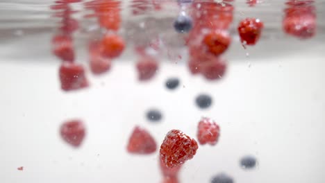 Underwater-shot-of-fresh-wild-berries-falling-into-clean-water