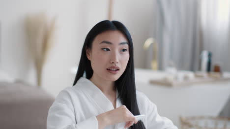 woman brushing her hair in a bedroom