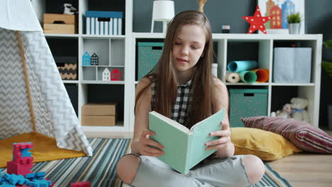 girl reading a book in a playroom