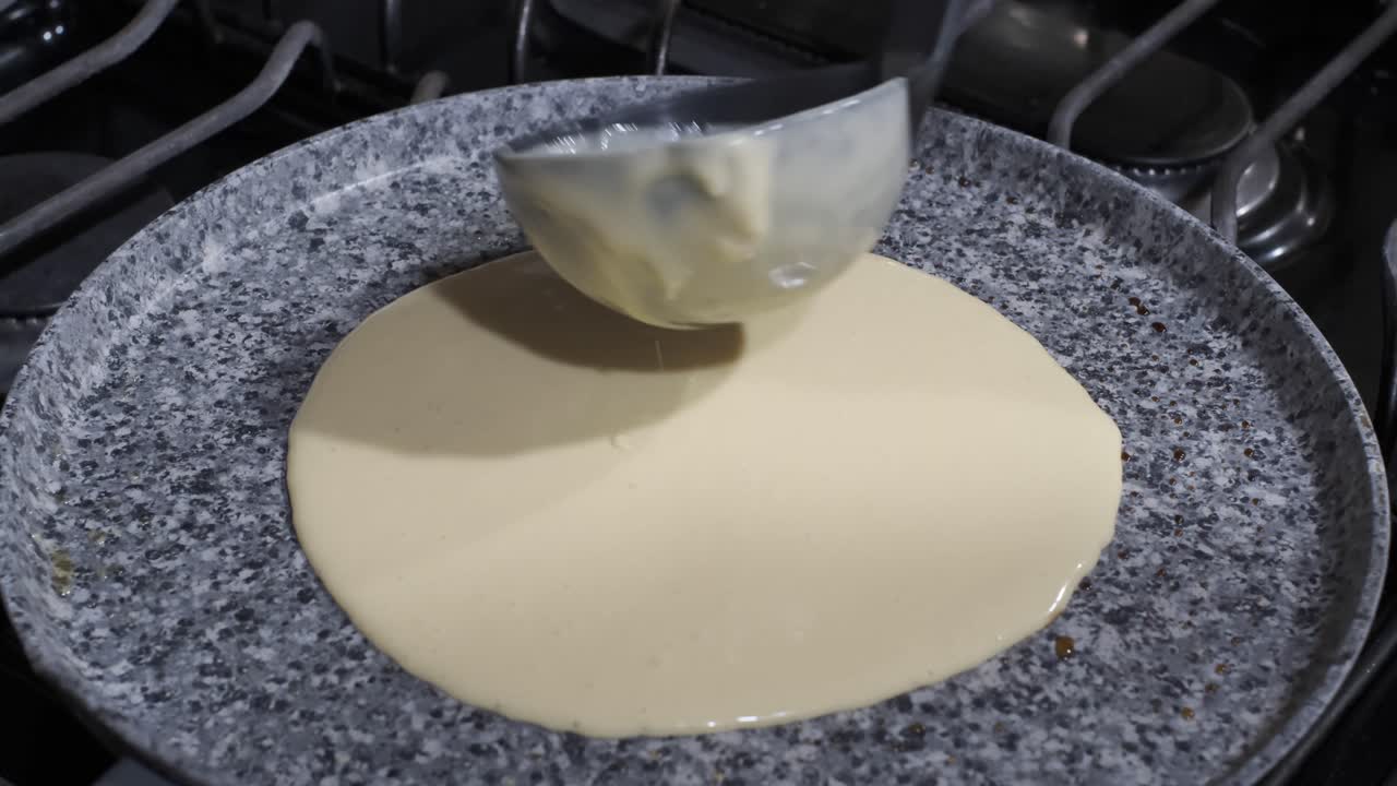 cuchara de cucharón vierte la masa de panqueques en una sartén caliente, desayuno de panqueques, ángulo alto
