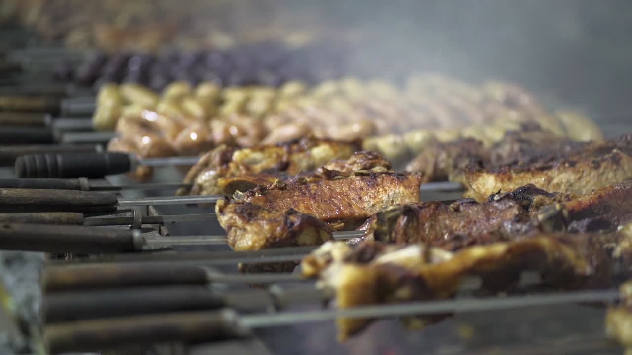 Primo piano di spiedini di pollo sulla griglia su fuoco vivo.