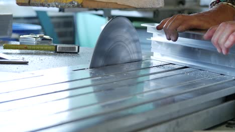 circular saw cutting through stainless steel in a metal factory