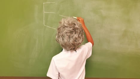 cute pupil writing maths on chalkboard