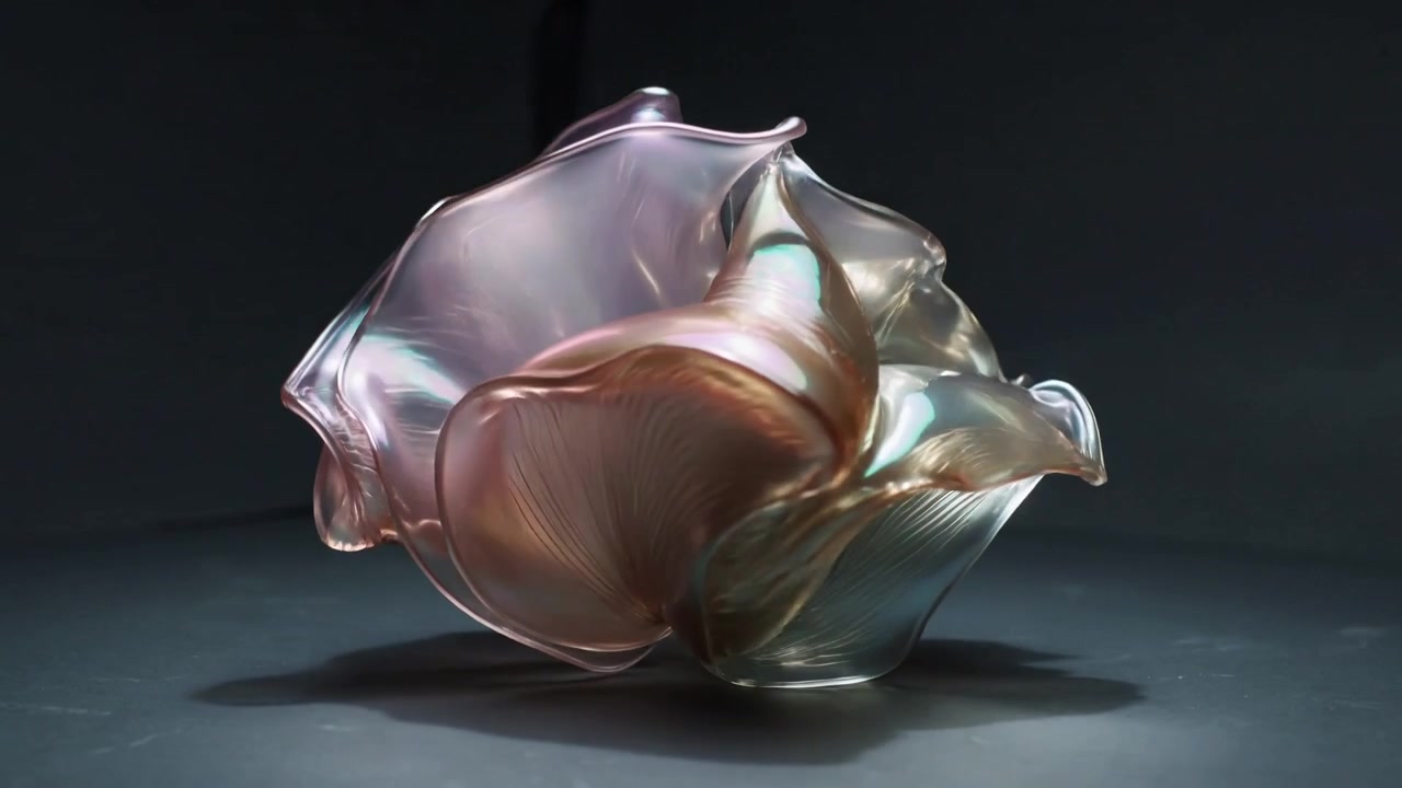 Turntable rotating pearlescent sculpture revealing ruffles under studio light, casting shadow