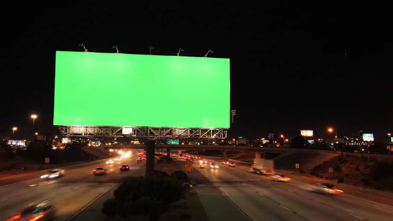 Una vibrante transición de una valla publicitaria verde en blanco a lo largo de una concurrida autopista, capturando la velocidad de los vehículos que pasan durante el atardecer y la noche, destacando la dinámica urbana.