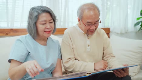 elderly couple looking at photos