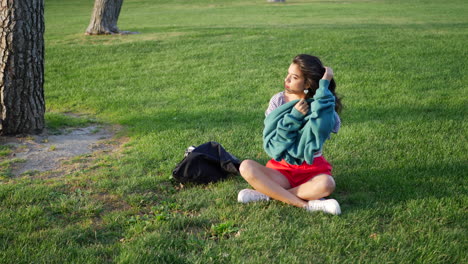 Eine-Schöne-Junge-Hispanische-Frau-In-Einem-Park,-Die-Versucht,-Sich-Bei-Windigem-Wetter-In-Der-Kalten-Jahreszeit-Mit-Ihrem-Pullover-Warm-Und-Gemütlich-Zu-Machen