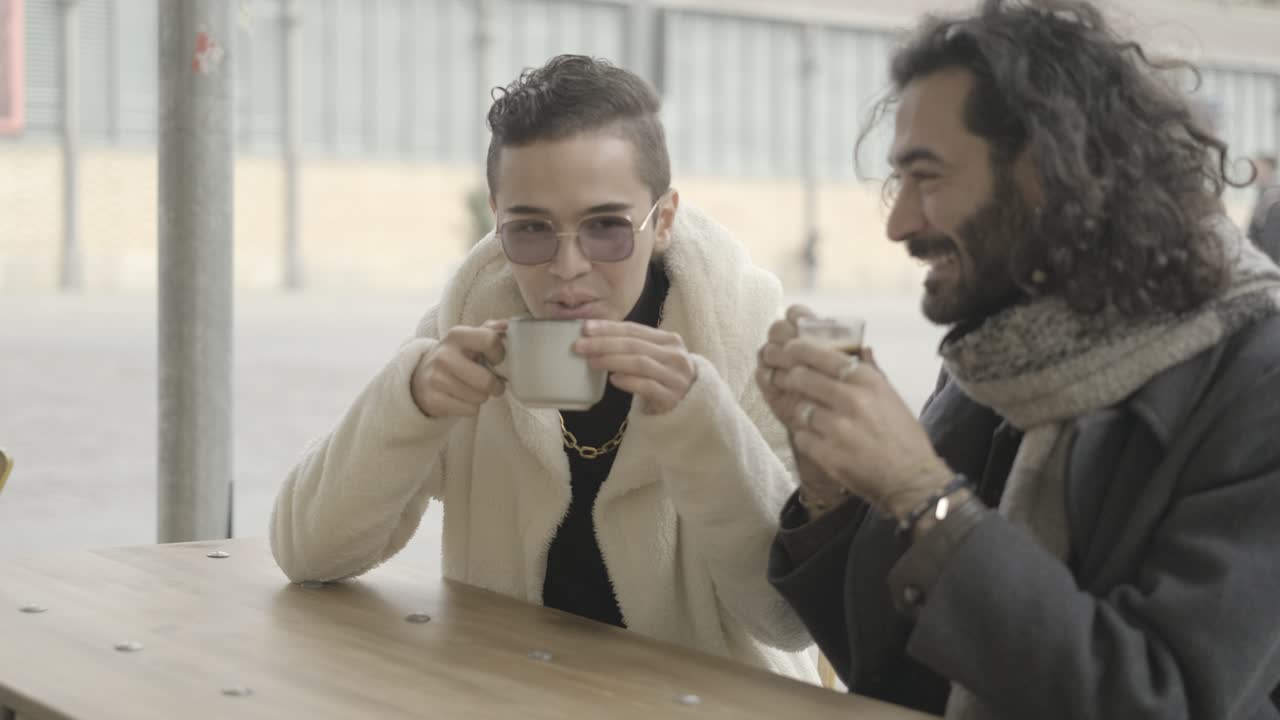 Two men having coffee and a conversation at a cafe