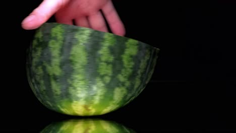 la mitad de la sandía girando en una pantalla negra