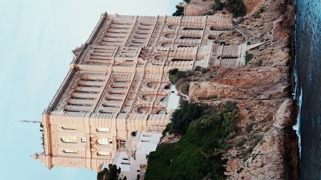 View of the The Oceanographic Museum of Monaco on the shore with the mountains on the background. Vertical