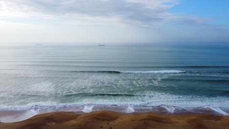 aerial-zoom-out-shot-of-the-wild-beach-of-french-landes,-relaxing-image-in-blue-and-brown-tone