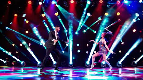 pareja bailando en el escenario con luces de colores