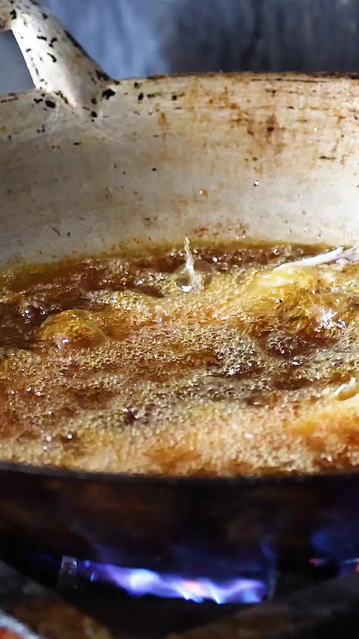 Sequential frying of fish in a pan over flame
