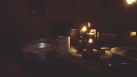 dinner setting in a dimly lit room with candles and empty plates