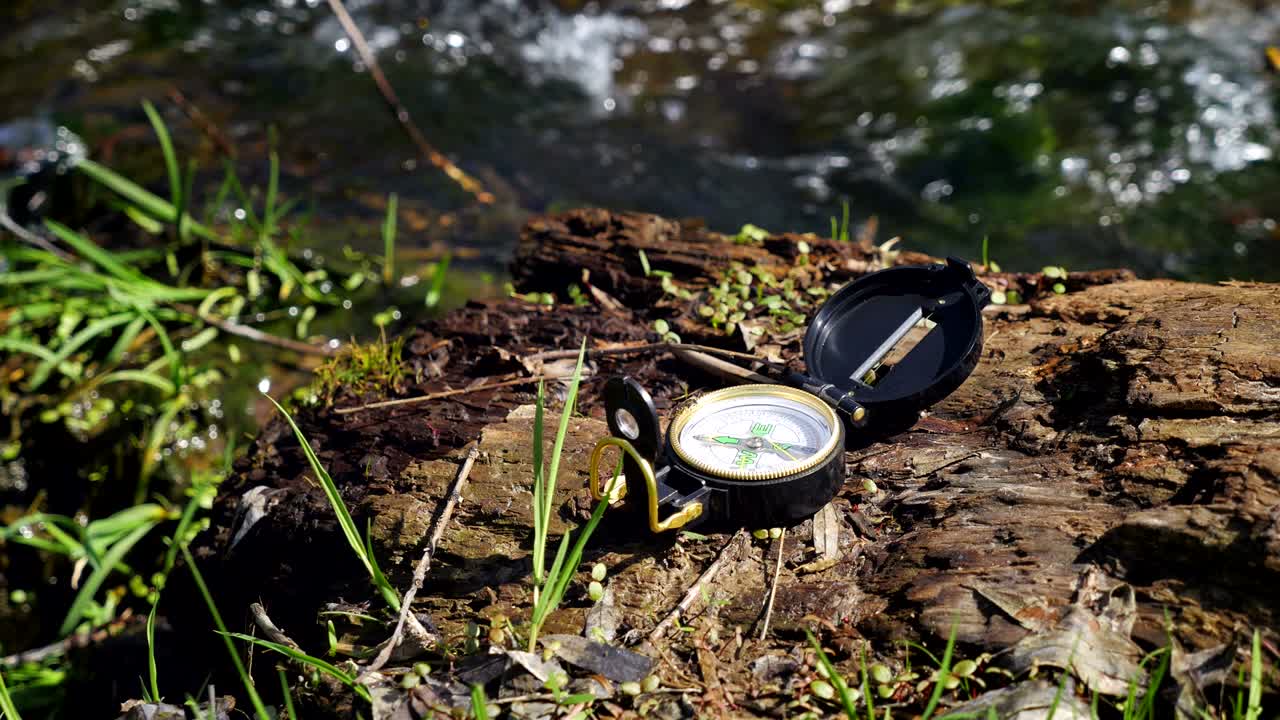 Compass on the wood near little stream