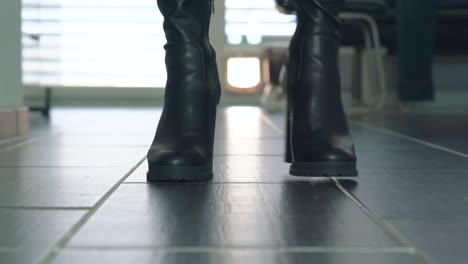 Girl-struts-in-front-of-the-camera-in-black-faux-leather-high-heels-block-heel-boots-around