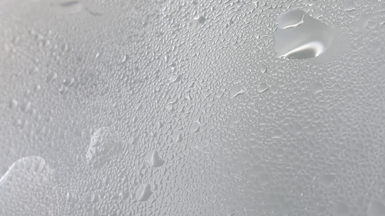Drops of steam from hot water on misted glass