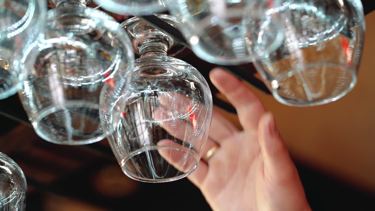 Wine glasses hanging on a rack in a bar.