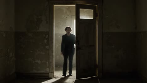 a figure stands in a dimly lit doorway, evoking a sense of mystery and anticipation, as shadows play across the walls of an abandoned room