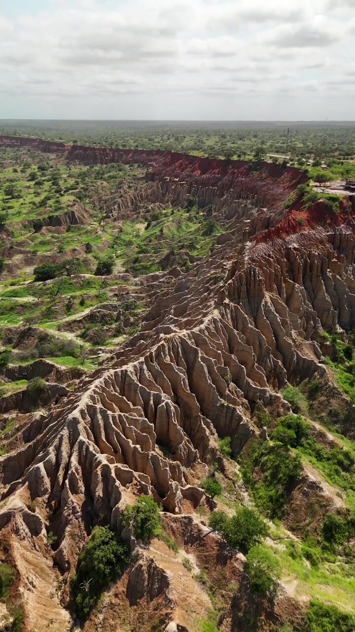 Splendida ripresa aerea dall'alto del famoso paesaggio lunare Miradouro da Lua, caratterizzato da spettacolari scogliere di argilla rossa, calanchi erosi e ampie vedute della savana nella provincia di Luanda, Angola.