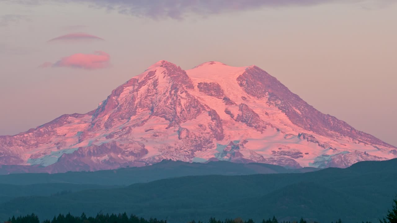 Riprese drone del Monte Rainier che si illumina di rosa al tramonto con una chiara silhouette alpina contro il cielo