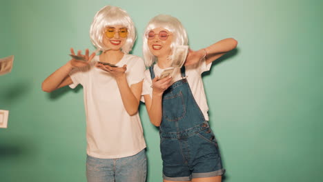 two young women celebrating with money