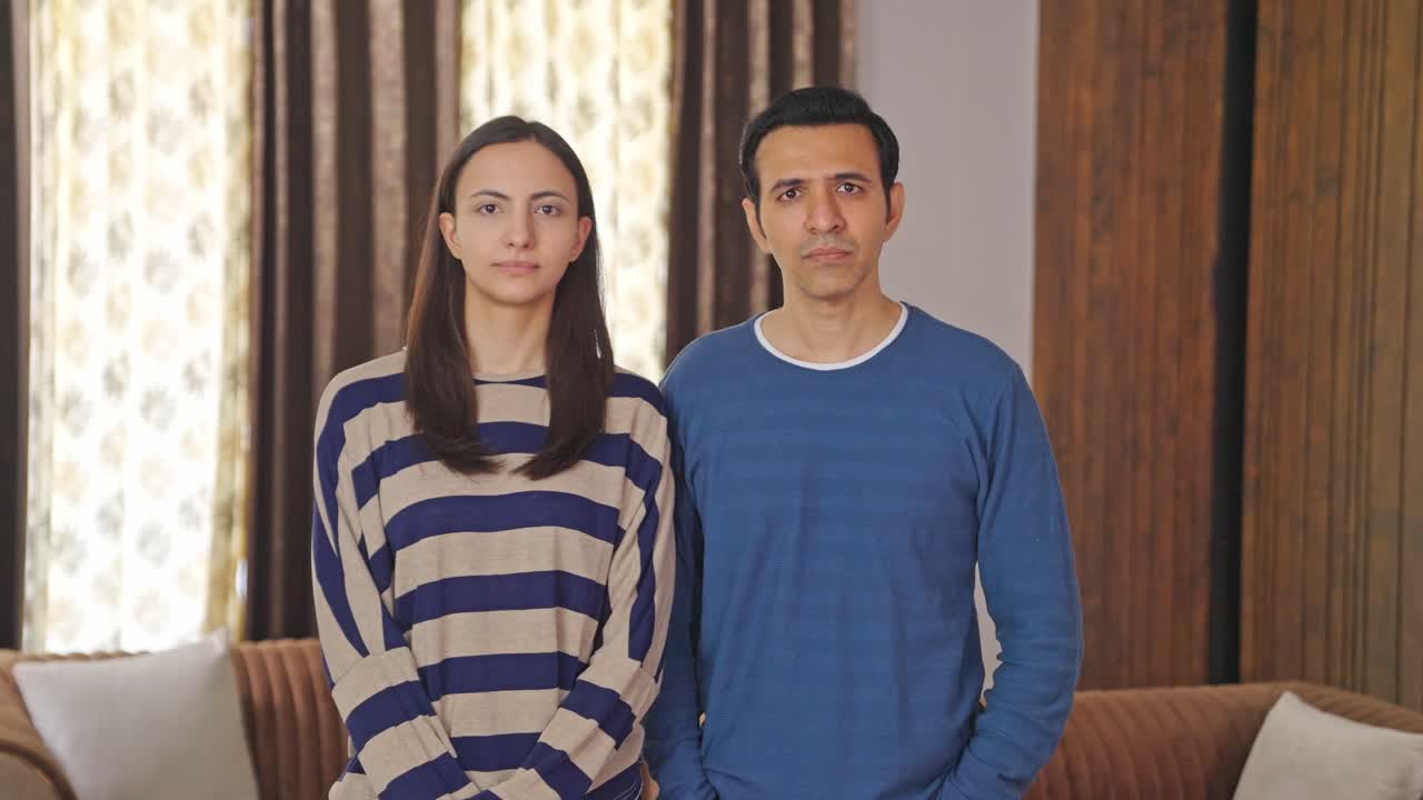 심각한 인도 커플이 카메라를 쳐다보고 있습니다.