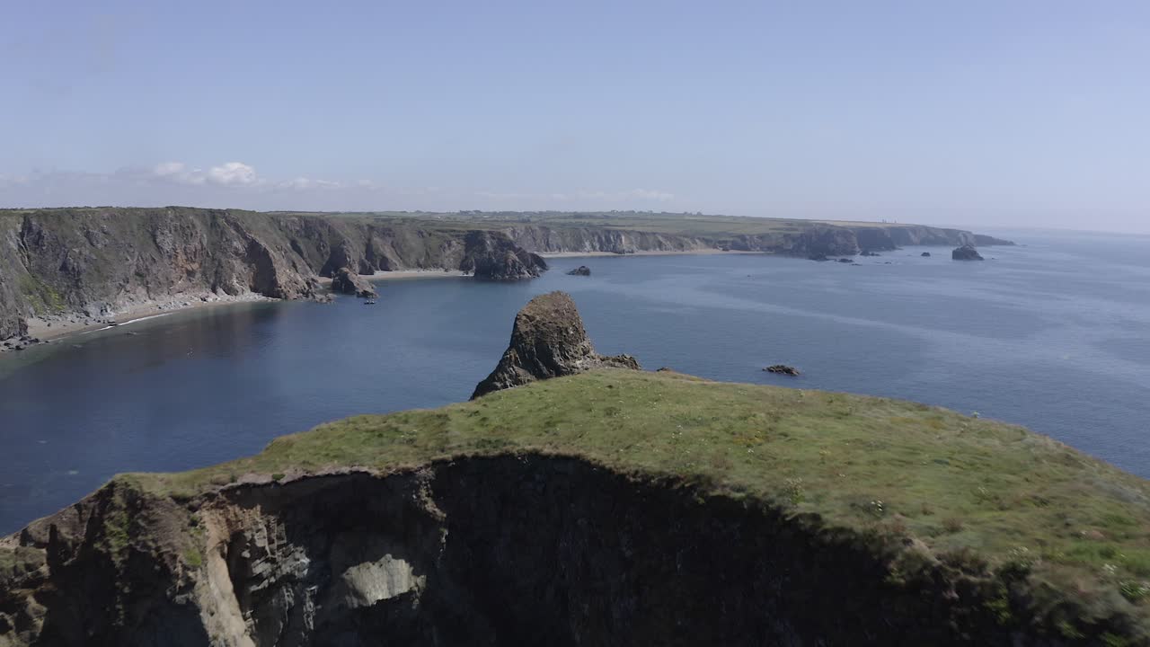 sobrevuelo aéreo bajo de la isla de ovejas cubiertas de hierba en la costa sur de irlanda