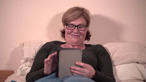 senior woman using tablet in bed