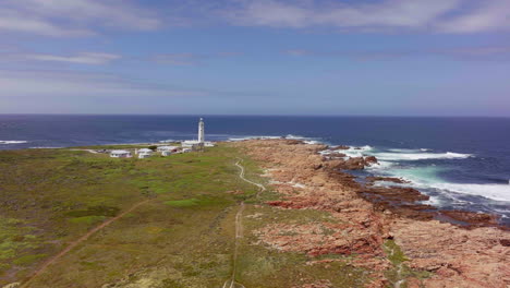 áfrica del sur faro del cabo san francisco ruta del jardín de verano jbay drone aéreo conducción cinematográfica desde still bay george impresionante hermosa tarde soleada costa accidentada olas gaviotas aves dando vueltas