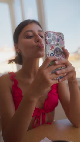 a young woman taking selfies indoors