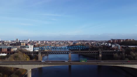 cars driving across bridges in newcastle upon tyne quayside on sunny autumn day - aerial drone 4k hd footage fly left