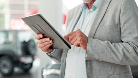 man using tablet in car dealership