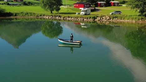 woman on the boat catches a fish on spinning in norway.