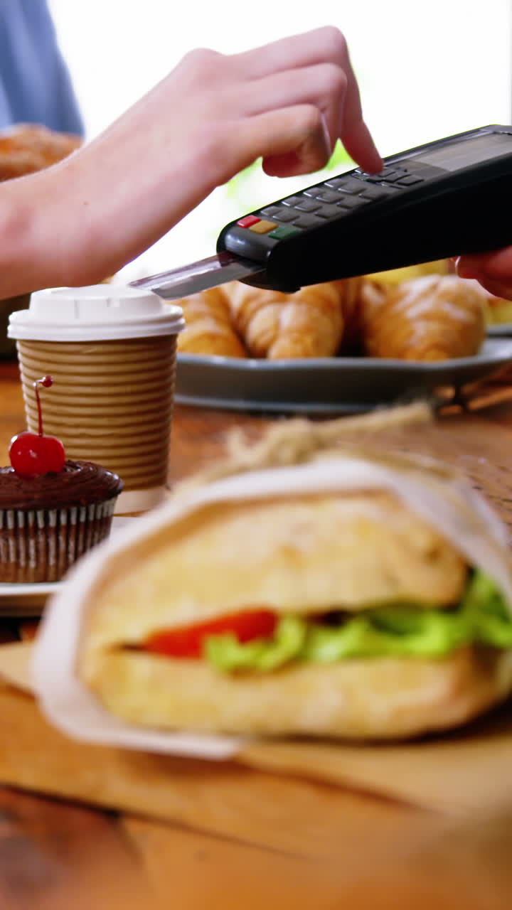 cliente que realiza un pago a través de una máquina terminal de pago en el mostrador