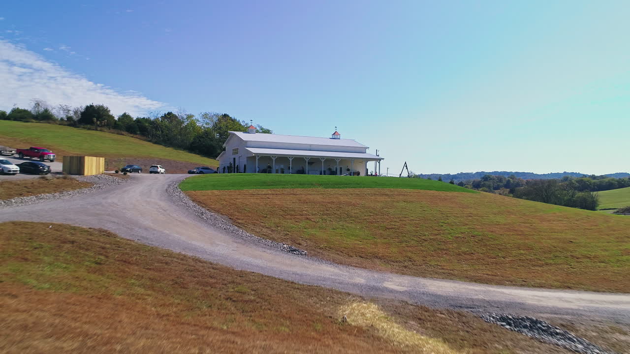 movimiento aéreo sobre el estanque y el granero para revelar una vista panorámica del campo, 4k